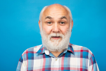 Fototapeta premium Mature surprised man with grey beard on studio background. Portrait of senior elderly caucasian old man.