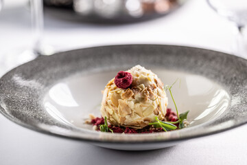 Tasty looking white chocolate cream with almonds, coconut and raspberries