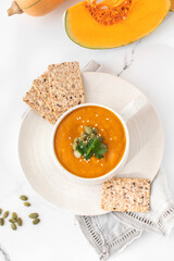 A mug of warm pumpkin soup. The concept of the autumn menu. Autumn recipes.