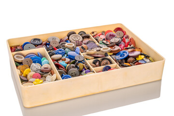 Many buttons in plastic container, macro isolated on white background.