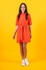 glad woman in summertime style isolated on yellow. woman in summertime style at studio. woman in summertime style on background. woman in summertime style wearing hat and dress