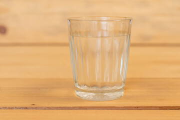 Glass of water on a wooden table. Selective focus.