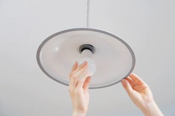 電球を交換する女性の手元
