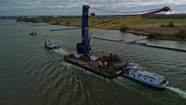 Aerial View Of Tug Boats Helping Floating Crane Along Oude Maas In Zwijndrecht