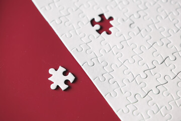 Clean puzzle elements on the red background. Empty puzzle piece on the table. Teamwork concept.