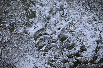 River stream blue color water flowing on stones. nature background.