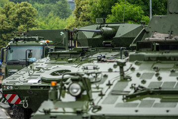 Armoured tanks and military infantry fighting vehicles ready to move under the rain, Lithuanian...