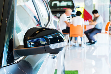 Side mirror on car of black modern car and background of new car service centers.