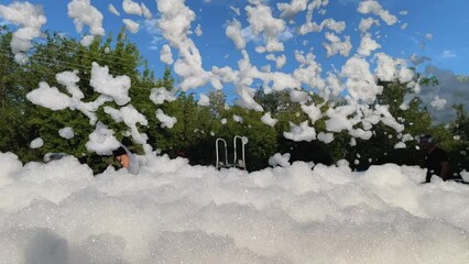 Foam party. Children have fun at birthday party outdoor in the yard. Slow motion