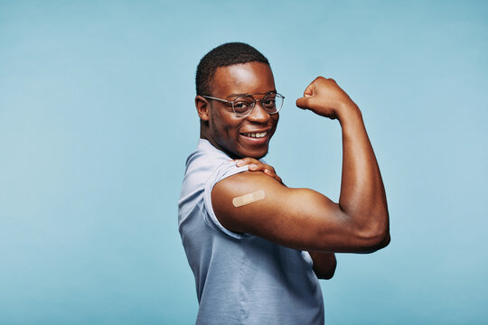 African man flexing after a vaccination