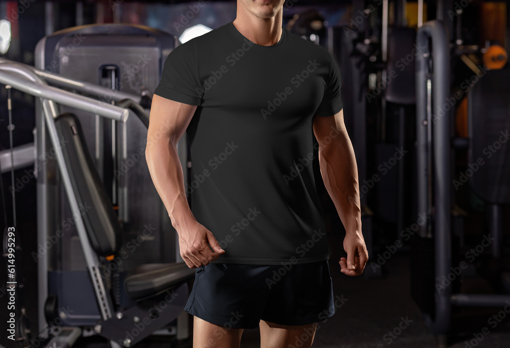 Wall mural Black t-shirt template on a posing athlete on the background of the gym, from head to knees, sportswear, front view. - Wall murals