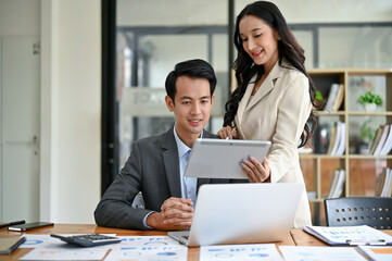 A beautiful Asian businesswoman is discussing work, analyzing business financial data