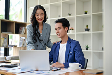 A female boss is training and briefing a male worker in the office on a new project.