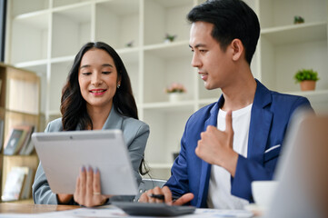 A smart businessman is giving a thumb up to a female colleague while working together.