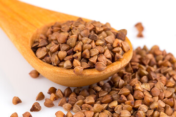 Uncooked buckwheat on wooden spoon