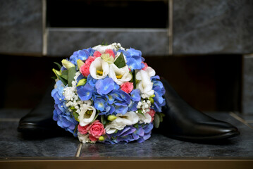 Wedding bouquet by the fireplace with black men's shoes