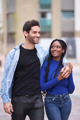 Happy multiethnic couple smiling while enjoying a walk together outdoors. Relationship concept.
