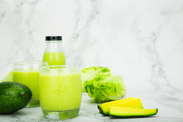 Avocado and green cos salad blended in a glass and bottle, healthy drinking water.  horizontal photo