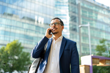 Portrait of an handsome businessman in an urban setting makin a phone call