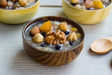 Traditional Turkish Dessert Ashure or Noah's Puding, designed in bamboo bowls on wooden surface