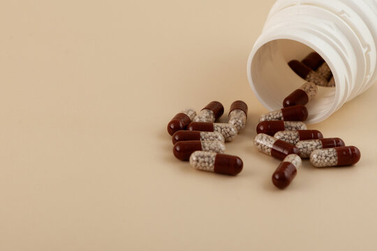 Creon pills spilled out of plastic jar, selective focus. Pancreatin capsules help the person digest fats, starches, and proteins. Pancreatic enzymes, also known as pancreases or pancrelipas