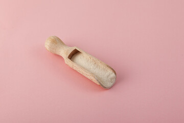 Xanthan Gum Powder in wooden spoon on pink surface. Food additive E415. Binding agent, Thickener. Controls viscosity. Used in cosmetic, and food industry