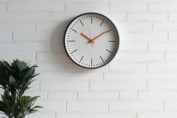 A wall clock with minimalist design, showing the time against a white wall, flat view, blurred background Generative AI
