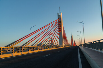 Fototapeta na wymiar Red cable car bridge and asphalt road. Bridge concept and architecture.