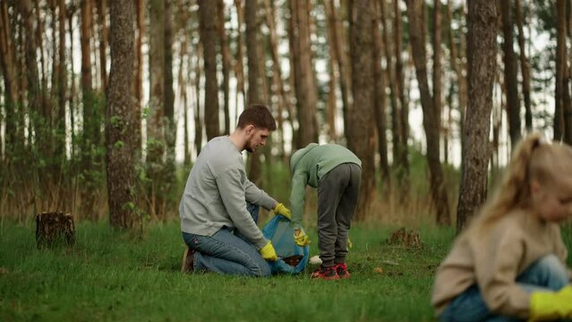 Environmental Protection, Volunteers Picking Garbage In Forest, Father And Son Working Together