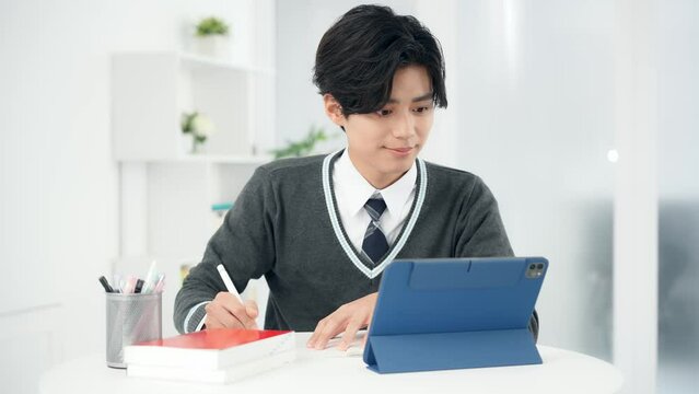 タブレットで勉強する男子学生