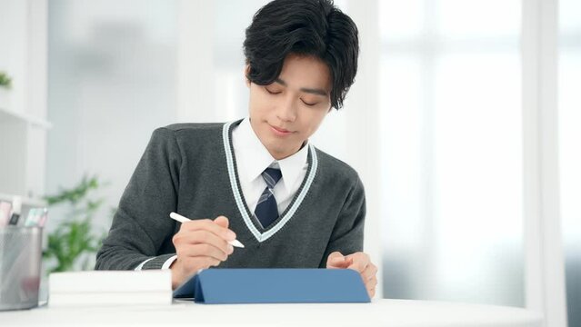 タブレットで勉強する男子学生