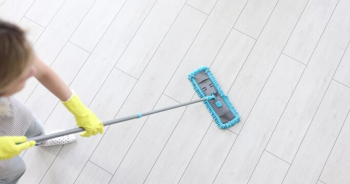 Woman hand washes floor with plastic mop. Home or office cleaning concept