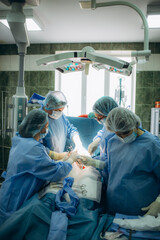 Surgical team performing surgery operation. Doctor performing surgery using sterilized equipment. Gynecologists and midwifes giving birth. Infant in maternity hospital