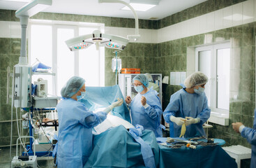 a group of doctors are preparing for a caesarean section