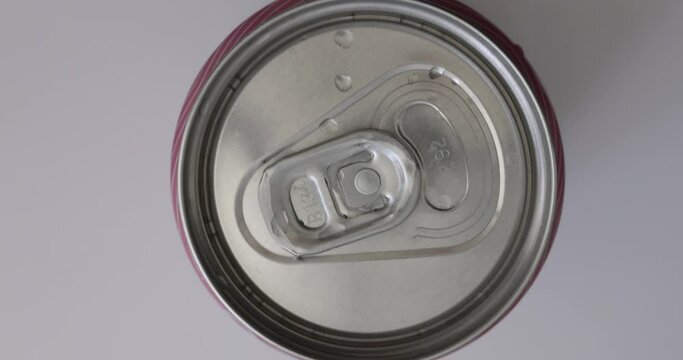 Closeup of rotating closed aluminum soda can. Aluminum pull tab on drink can