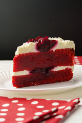 Piece of red velvet cake on white table