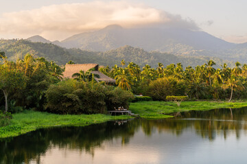 landscape with lakeside house river and big mountains with tropical palm forest in sierra nevada de santa marta parque tayrona 