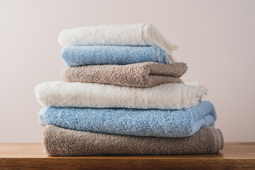 Stack of blue white beige cotton terry towels close up view. Bathroom interior details with copy...