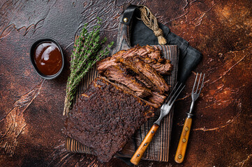 Traditional smoked barbecue wagyu beef brisket on wooden board. Dark background. Top view