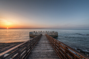 Morning on the pier and the roundabout overlooking the sea with the splendid colors of sunrise