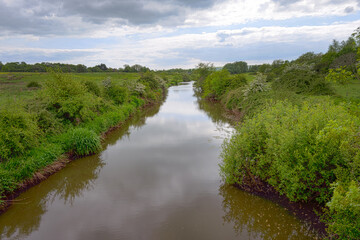 Fototapeta na wymiar Cuckmere river near Arlington reservoir, East Sussex, England, on a cloudy spring afternoon