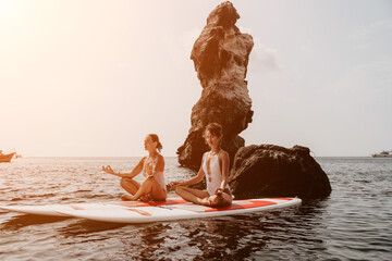 Woman sup yoga. Happy sporty woman practising yoga pilates on paddle sup surfboard. Female...