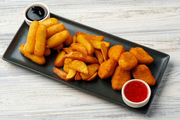 Fried snacks platter with sauce on gray wooden table