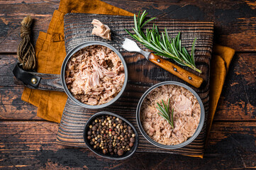 Can with Conserved tuna fillet meat. Wooden background. Top view