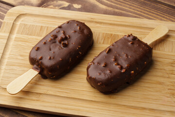 Chocolate cake pops ice creams on wooden board close up