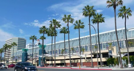 View of the Long Beach Convention and Entertainment Center with palm trees, people and transportation traffic in Long Beach, California, 4K