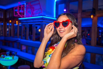 Attractive latin woman at a night party in a disco with glasses of hearts