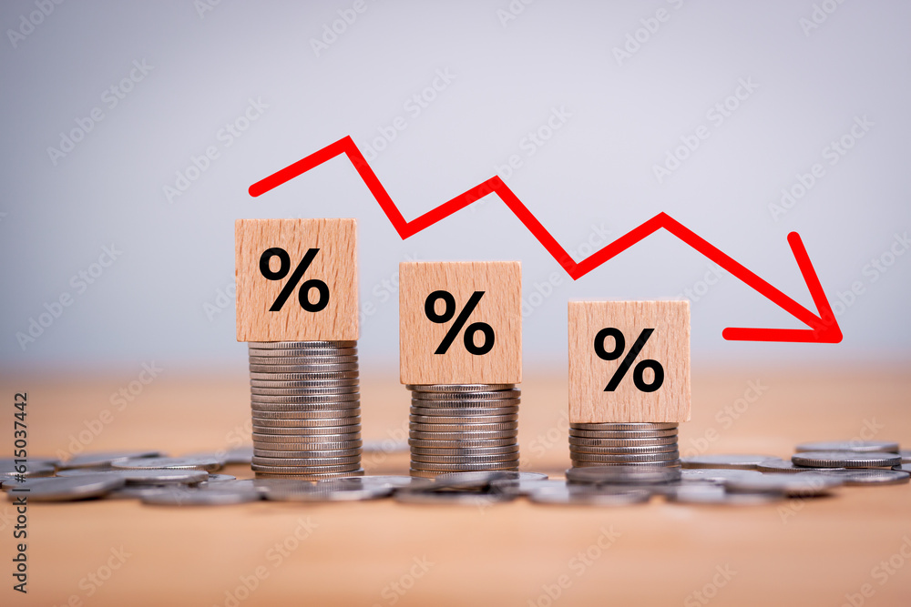 Poster percentage sign on wooden cubes with stack of coin bar chart and red graph trending downwards on whi