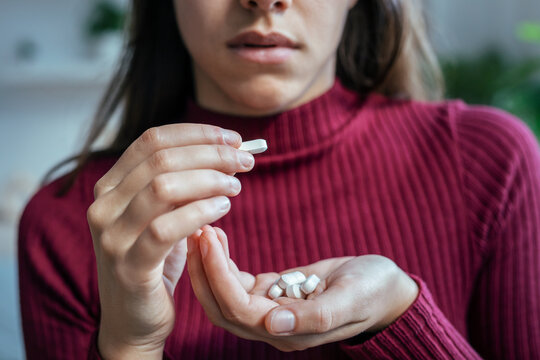 Young woman with depression and anxiety taking pills at home