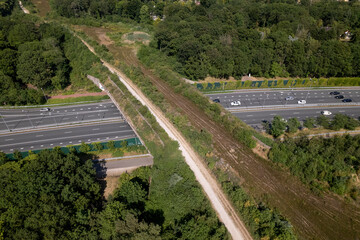 Interstate freeway with wildlife crossing green corridor bridge for animals to migrate between...